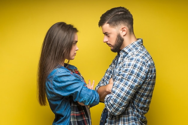 戦っているデニムの服を着た怒っている男性と女性の写真