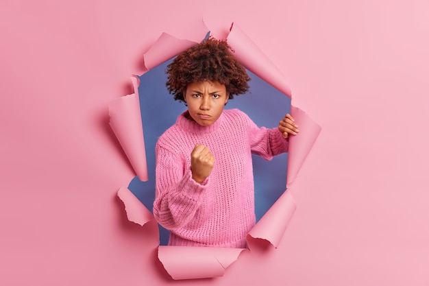 La foto di una donna dalla pelle scura infastidita con i capelli afro stringe il pugno dimostra rabbia