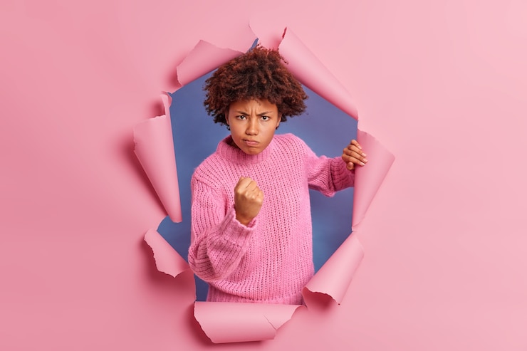 Free Photo photo of annoyed dark skinned woman with afro hair clenches fist demonstrates anger