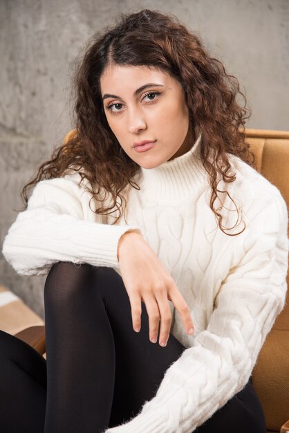 Photo of attractive lady sitting in comfy chair and posing