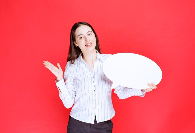 Photo of a beautiful business woman holding an empty speech bubble.