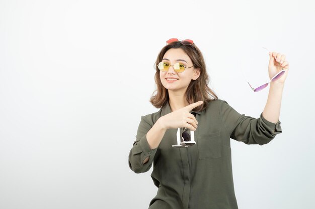흰색 위에 포즈를 취하는 다채로운 선글라스와 함께 아름 다운 여자의 사진. 고품질 사진