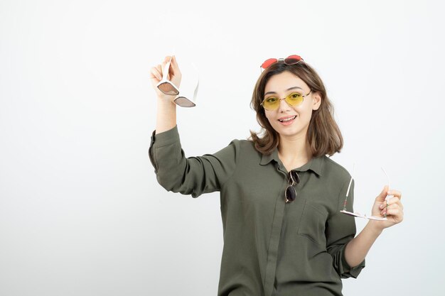 흰색 위에 포즈를 취하는 다채로운 선글라스와 함께 아름 다운 여자의 사진. 고품질 사진