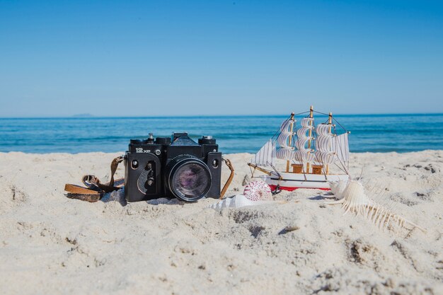 Photo camera and miniature of ship 