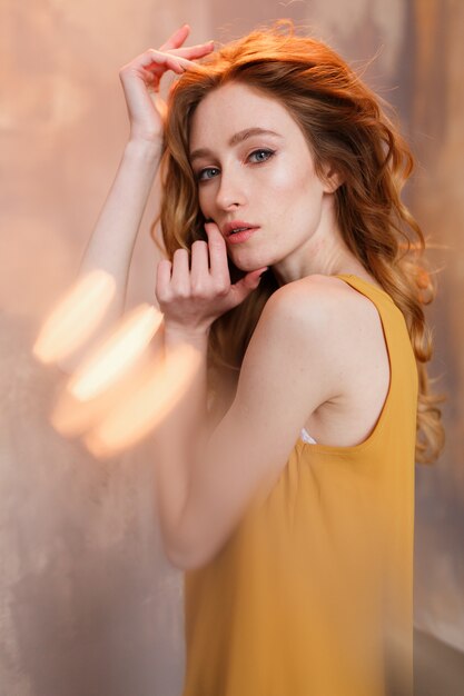 Photo of cheerful redhead young woman in mustard dress and jeans