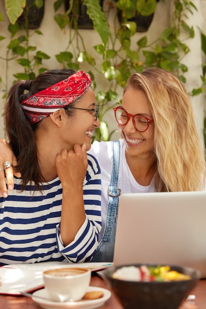 Foto gratuita la foto di due donne allegre guarda con un sorriso