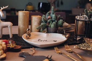 Photo of christmas table decoration with festive dinnerware with candles. new year eve concept