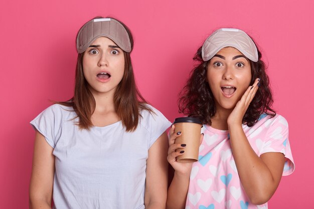 感情的なかなり若い女性がコーヒーを直接持ち、口を大きく開いてショックを受けているのを見て