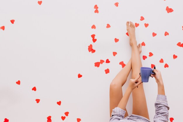 Photo of female legs on red confetti