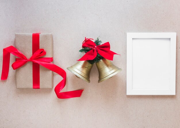 Photo frame between Christmas bells and gift box