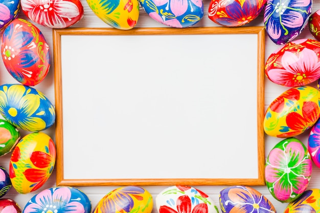 Free photo photo frame between collection of easter eggs