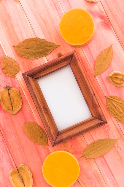Photo frame between dry leaves and fruits