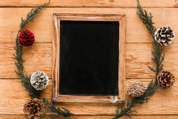 Photo frame near coniferous twigs and ornament snags