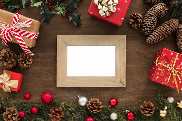 Photo frame near fir twigs, snags, presents and Christmas toys