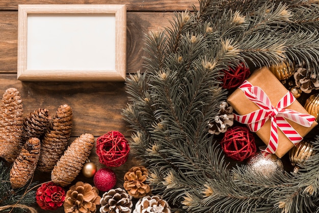 Photo frame near present box and fir branches 