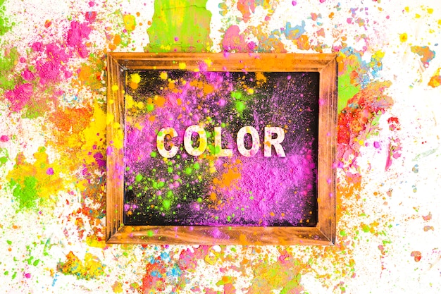 Free photo photo frame with color inscription between heaps of bright dry colours