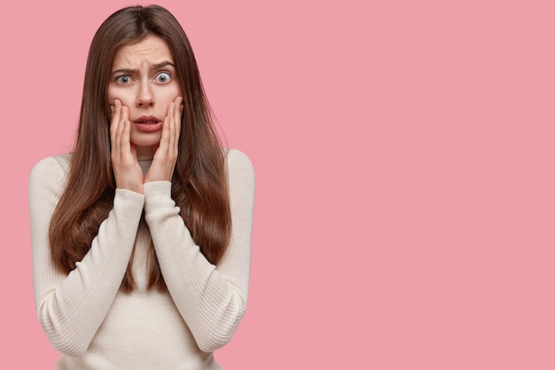 Scared, worry and face of Indian woman on pink background with