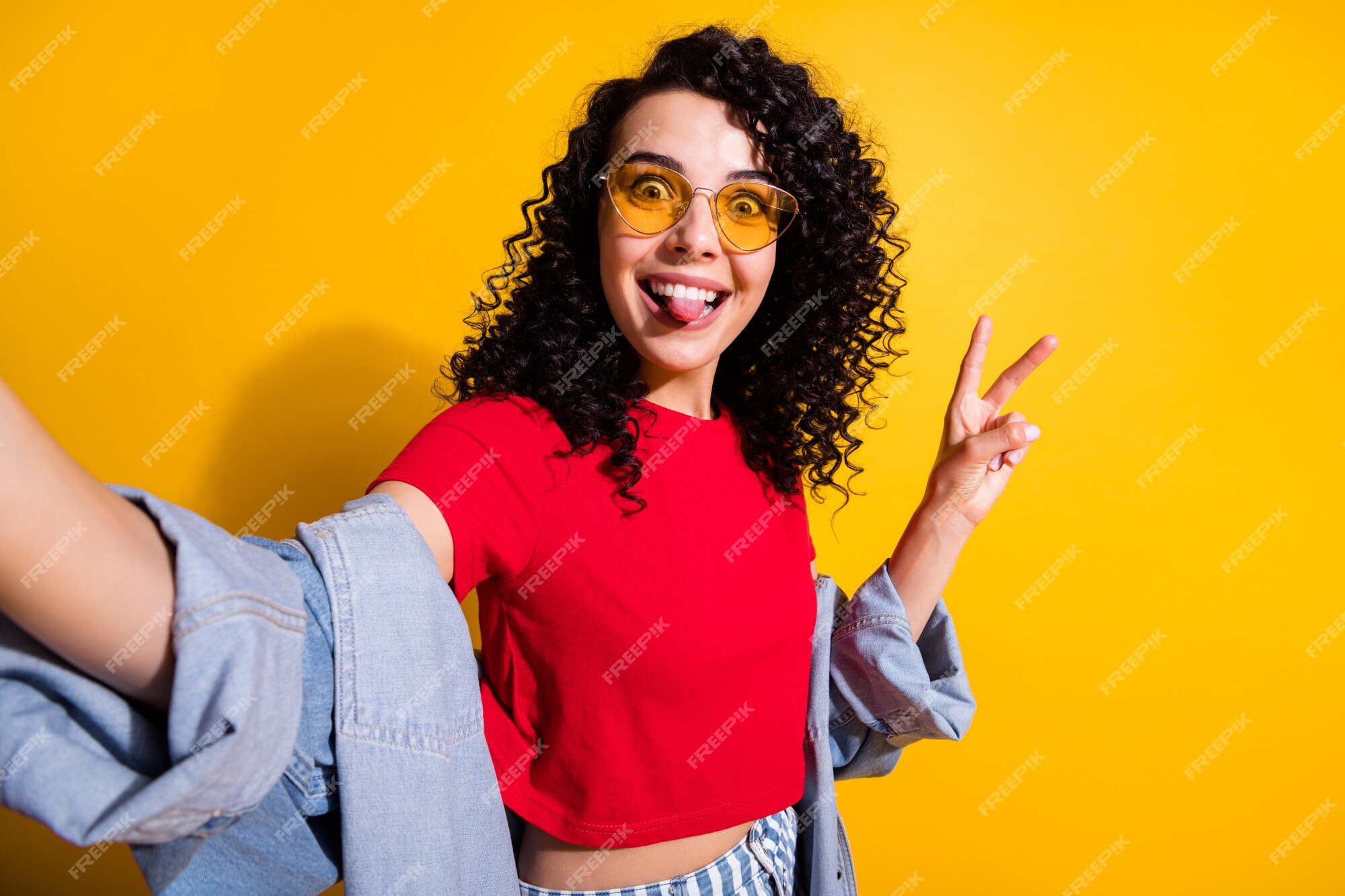 Premium Photo | Photo of funny cute girl take selfie tongue-out show v-sign wear  red t-shirt jacket sunglass isolated yellow color background