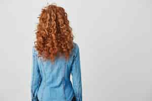 Free photo photo of girl with red curly hair standing back to camera . copy space.