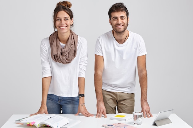 Foto gratuita foto di giovani studenti maschi e femmine felici si appoggiano al tavolo