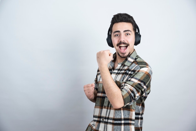 Free photo photo of handsome guy in headphones singing a song and dancing.