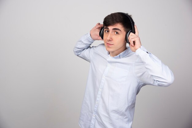 Photo of a handsome guy model standing and wearing headphones