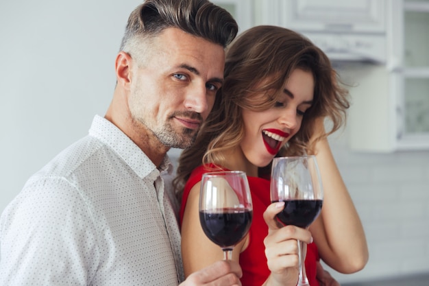 Photo of handsome man hug his woman while drinking wine