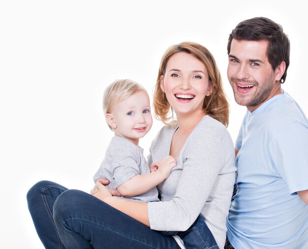 Photo of the happy young family with little child sitting