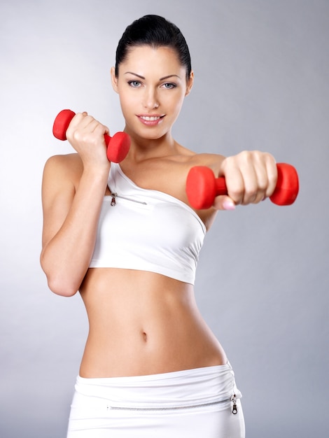 Photo of a healthy training young woman with dumbbells.  Healthy lifestyle concept.