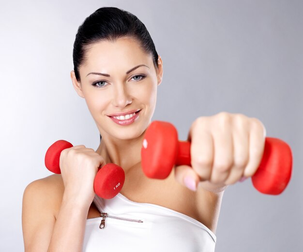 Photo of a healthy training young woman with dumbbells.  Healthy lifestyle concept.