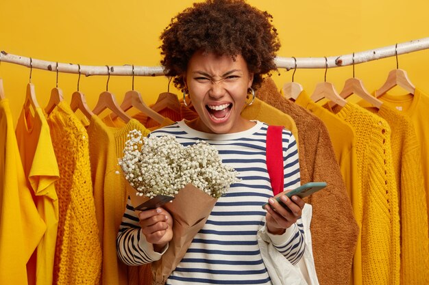 Photo of irritated woman shopaholic screams very loudly, cannot pay for purchase, has problems with transaction