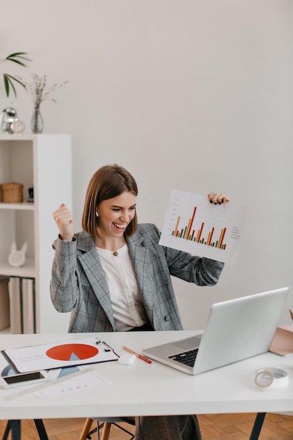 Foto di una signora di ottimo umore che racconta ai dipendenti tramite collegamento video il miglioramento delle condizioni economiche dell'attività