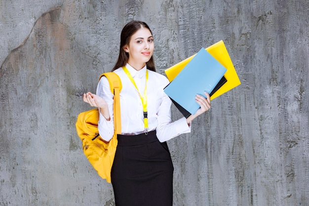 Photo of long haired student showing colorful notebooks. high quality photo