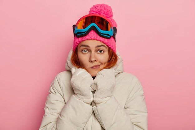 На фото симпатичная путешественница поджимает губы, зимой греется в удобной верхней одежде, носит лыжную маску.