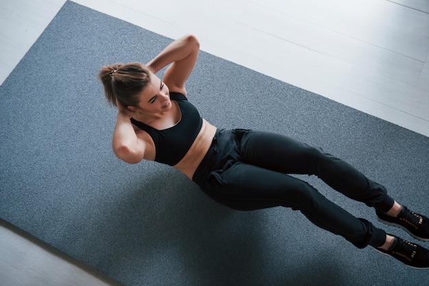 모션 사진. 체육관 바닥에서 복근 운동하기. 아름 다운 여성 피트 니스 여자