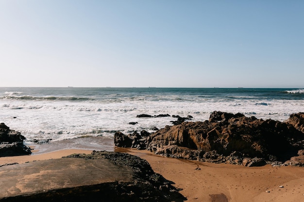 Free photo photo of ocean road ocean shore with rocks in sunlight incredible sunset on the ocean portugal