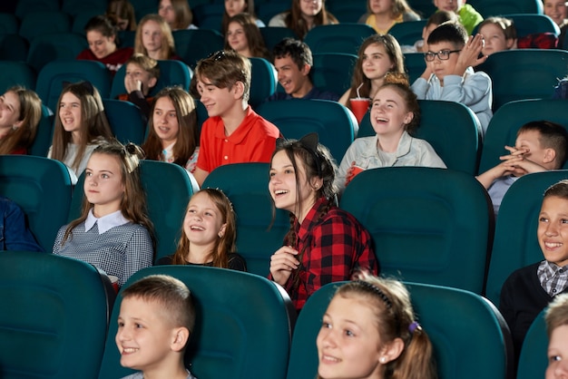 영화관에서 영화를보고 웃고 행복한 아이들의 사진.