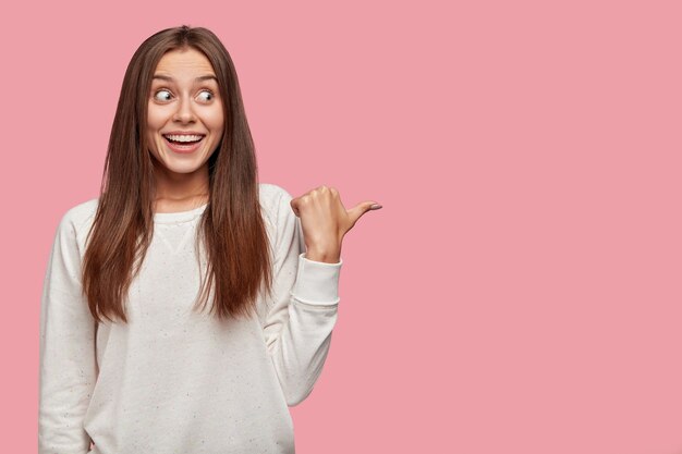 Photo of pleasant looking cute teenager has dark long hair, appealing look