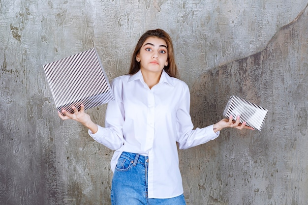 Foto gratuita foto di una bella modella con i capelli lunghi che tiene in mano scatole di regali