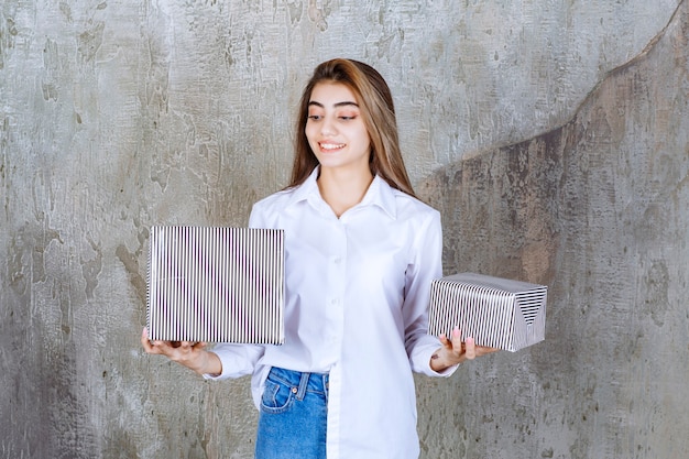 Photo of a pretty girl model with long hair holding present boxes