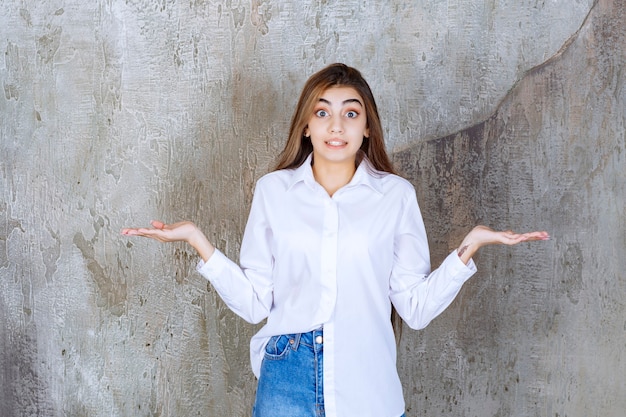 Photo of pretty young woman standing and posing over marble