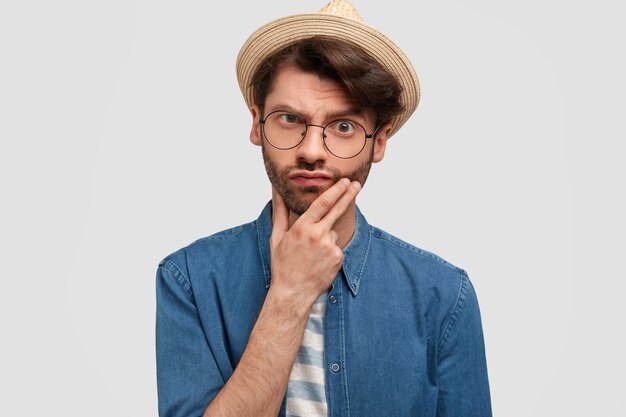 Photo of puzzled bearded male looks in bewilderment