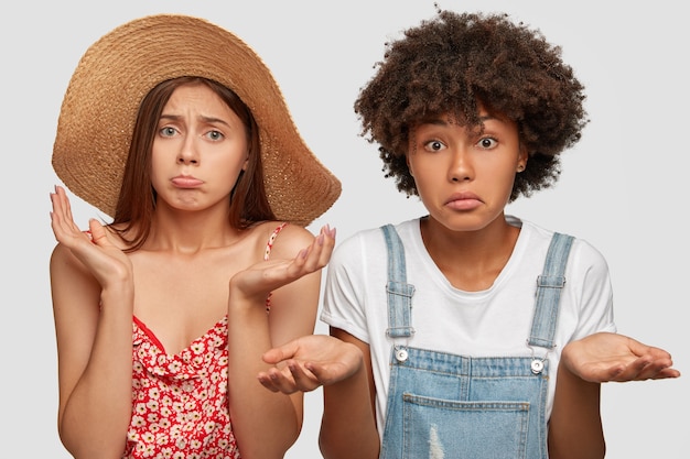 Free photo photo of puzzled hesitant mixed race women look with clueless expressions