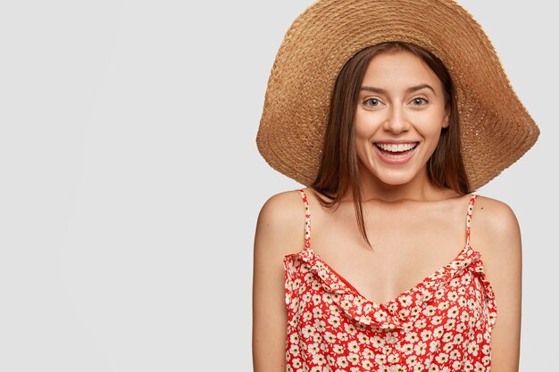 Photo of satisfied Caucasian woman with toothy smile, expresses joy, has pleased expression