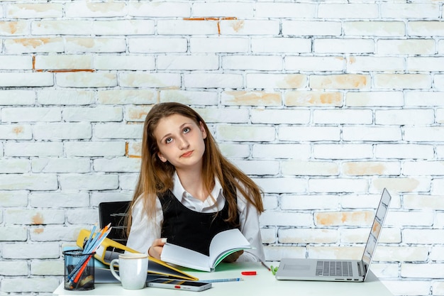 Photo of school girl feeling tired and holding her notebook