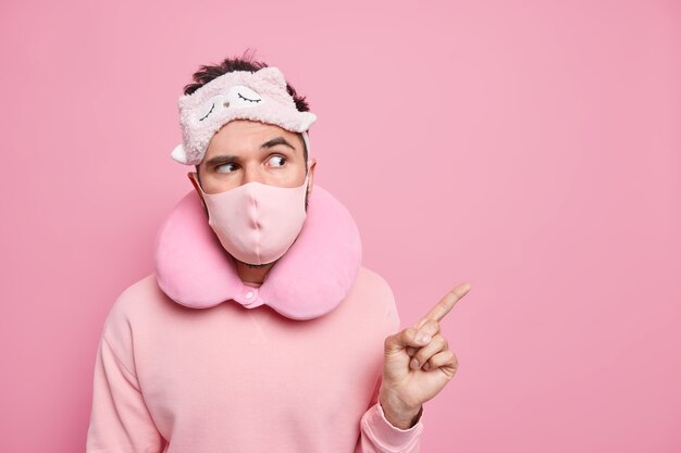 Foto di punti attenti seri nell'angolo in alto a destra vestiti con un cuscino di maschera protettiva per la maschera da notte del maglione intorno al collo