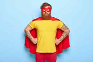 Free photo photo of serious male in superhero costume, keeps hands on waist, possesses extraordinary talents