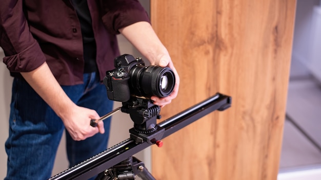 Sessione fotografica a casa. photograpger tenendo la fotocamera sulla barra orizzontale