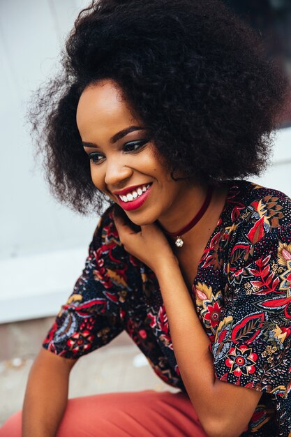 Photo of a smiling attractive afro american woman with colorful makeup and white teeth