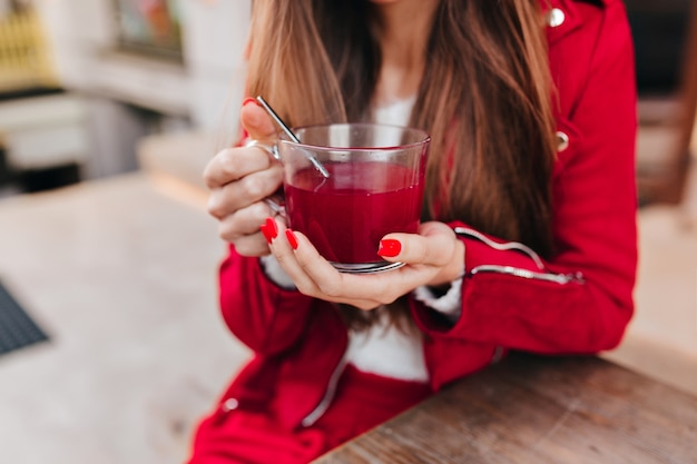 Photo of stylish white woman with cup of tea on foreground